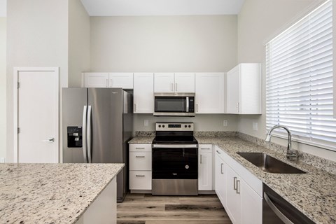 a kitchen with granite counter tops and stainless steel appliances