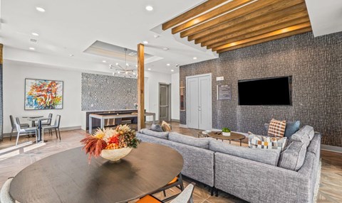 A living room with a grey couch, a coffee table, and a painting on the wall.