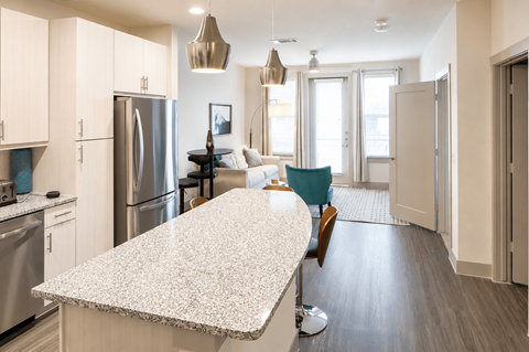 A kitchen with a granite countertop and stainless steel appliances.