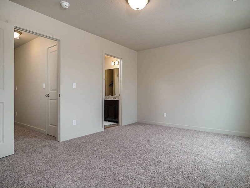 an empty living room with a door to a bathroom