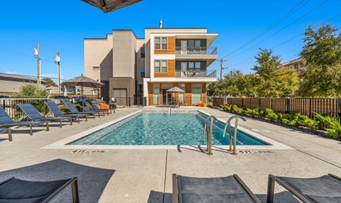 Resort style pool with lounge seating at Avion at West Lemmon Apartments, Texas