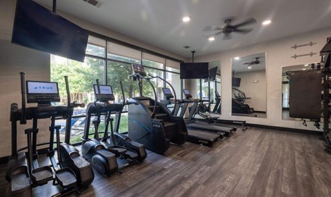 Fitness center with ellipticals and strength training equipment at The Mark at Midtown Apartments, Dallas, TX 75231