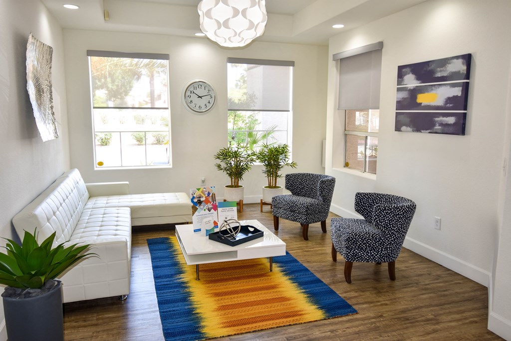 Modern White Leather Couch sits opposite 2 patterned blue chairs in Main Lobby