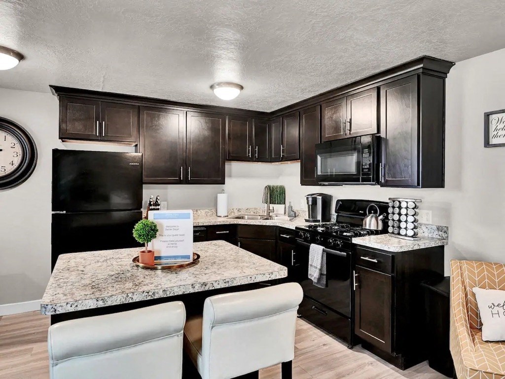 a kitchen with black cabinets and a granite counter top