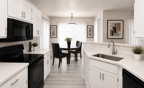 A black and white kitchen with a table and chairs.