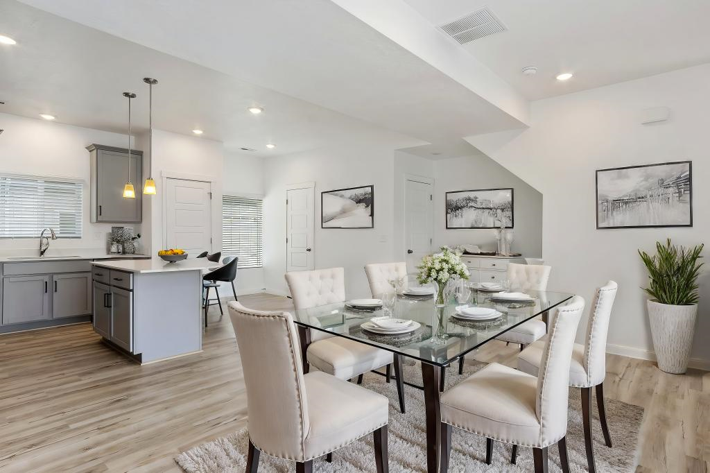 A modern dining room with a glass table and white chairs.