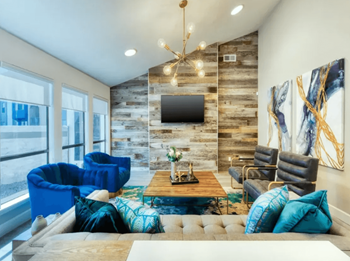 Resident Clubhouse with Blue Cozy Chairs, Rock Patterned Wall, TV, and Ample Seating Opportunities at Enclave at Paradise Valley in Phoenix, Arizona 85032