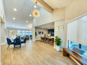Resident clubhouse with working tables, cozy seating, and high ceilings with pendant lighting at Enclave at Paradise Valley in Arizona 85032