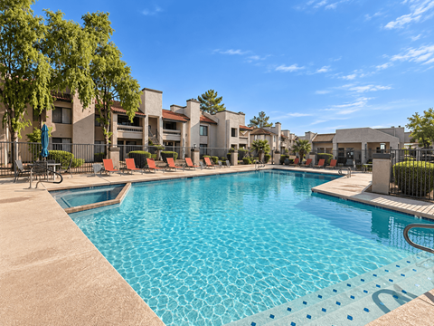 A large swimming pool with a blue tiled edge and a small pool next to it.