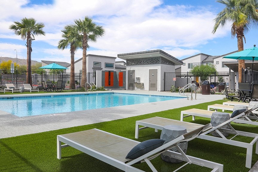 a swimming pool with lounge chairs and palm trees