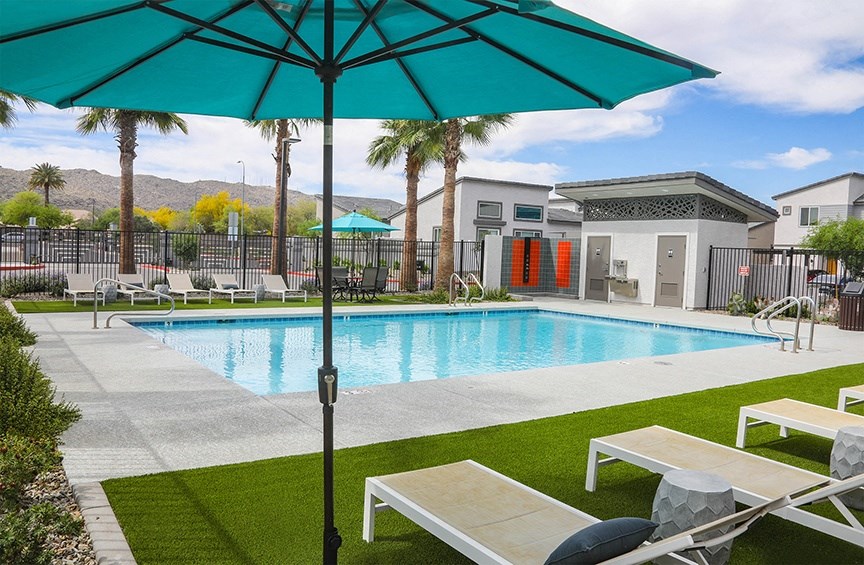 our apartments have a pool and lounge chairs with an umbrella