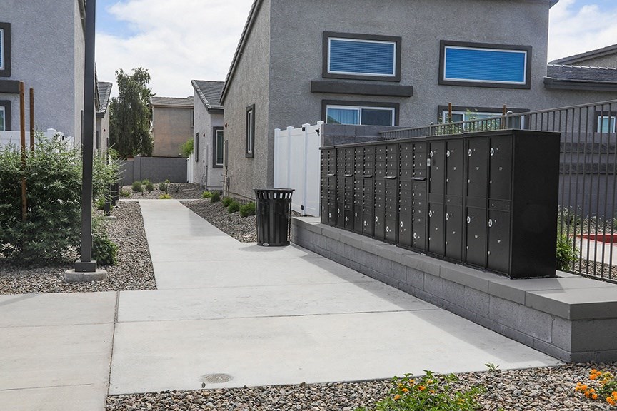 a fence and a trash can in front of a house