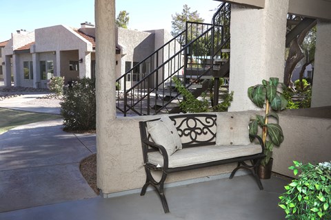 a bench sitting on a porch in front of a building