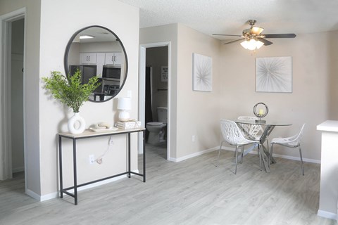 a living room with a mirror and a dining room table