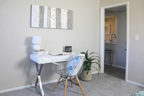 a home office with a desk and a chair and a potted plant