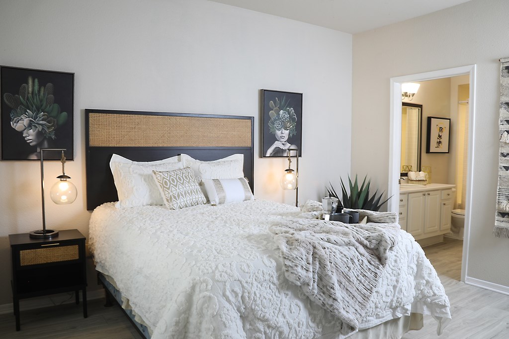 A bedroom with a large bed and two lamps on side tables.