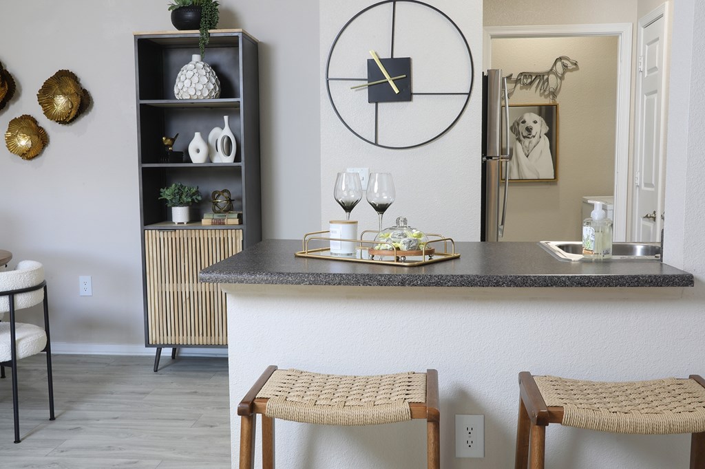 A kitchen with a bar area and two chairs.
