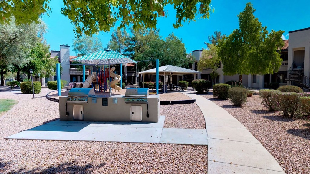 Two Stainless steel gas BBQ grills showing view of picnic area and playground