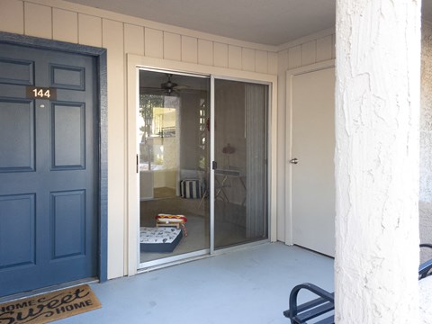 Large patio in front of apt showing sliding glass door leading to living space