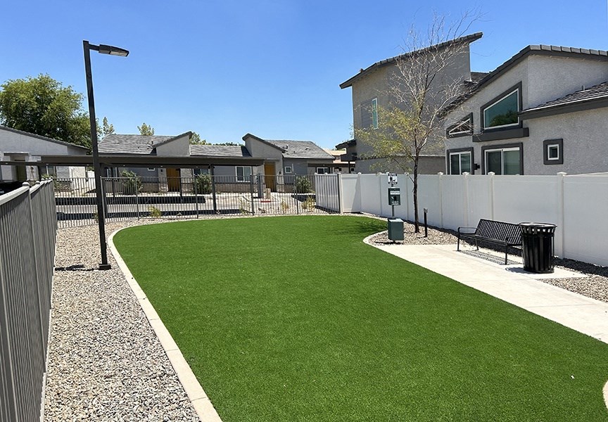 a backyard with a green lawn and a fence