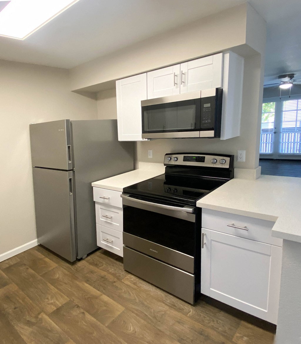 a kitchen with stainless steel appliances and white cabinets at Stonebridge, Phoenix