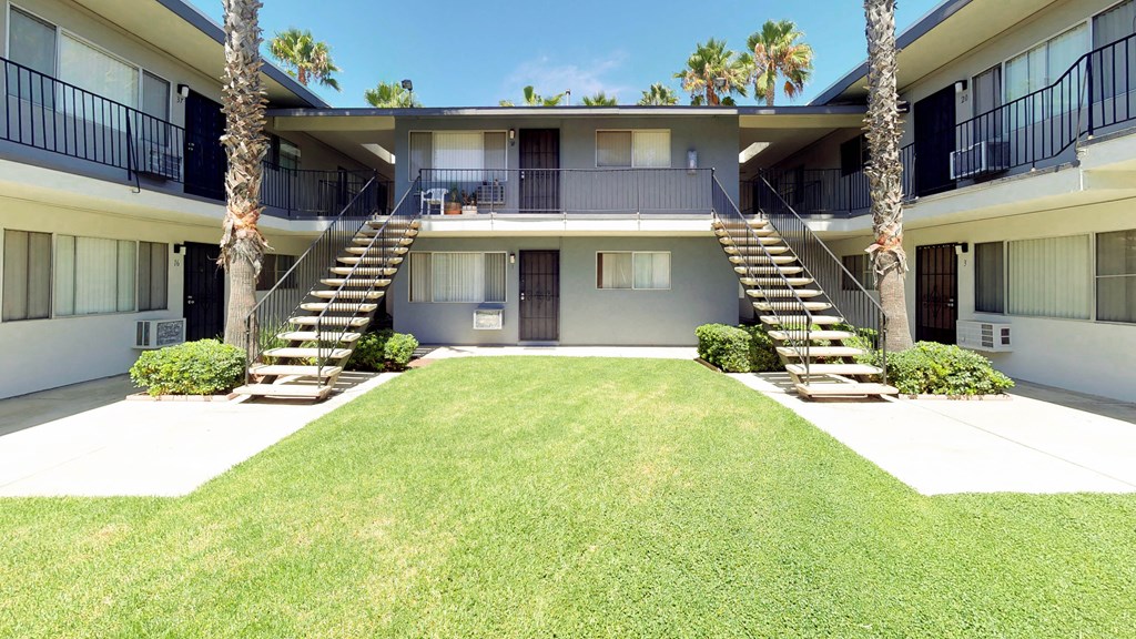 a building with stairs and a lawn in front of it