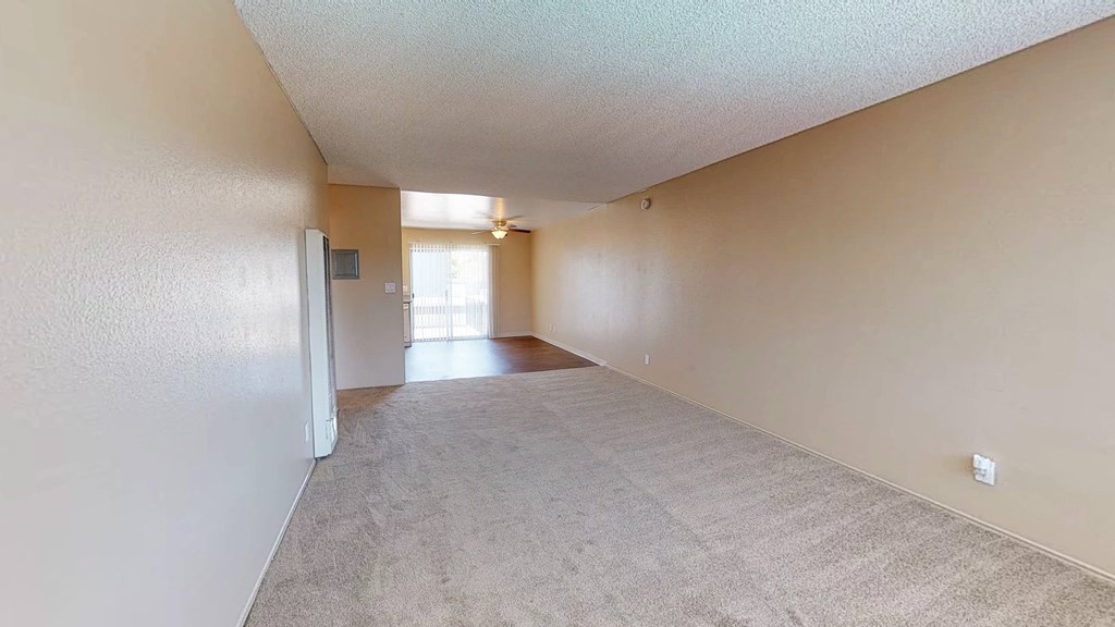 the living room and dining room of an empty house