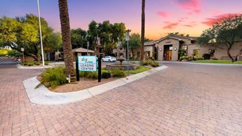 Paved driveway leading to leasing office during sunset