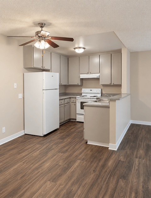 A kitchen with a white refrigerator and a white stove top oven.