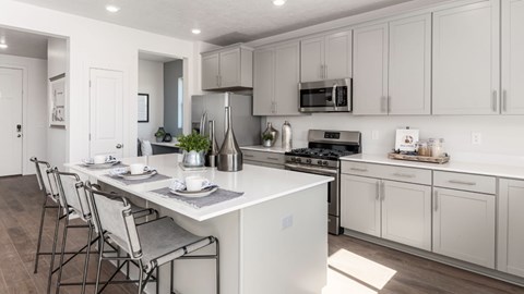 A modern kitchen with white cabinets and a central island.