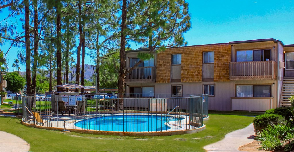 a large swimming pool in front of an apartment building