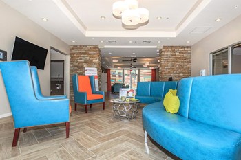 Leasing Office 2 Bright blue modern couch sits opposite 2 separate cushioned chairs - Photo Gallery 3