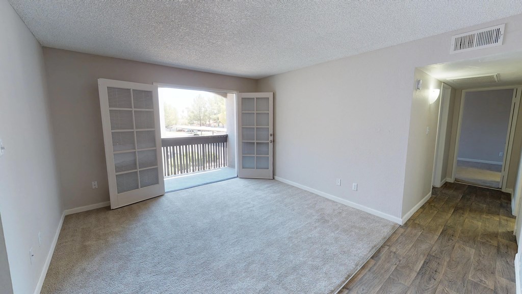 an empty living room with a window and a door to a balcony at Stonebridge, Arizona, 85032