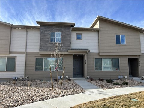 A modern two-story house with a grey and beige exterior.
