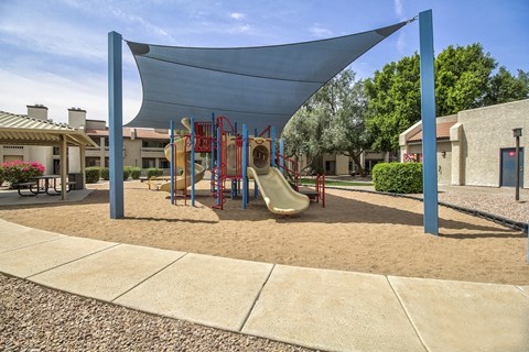 a playground with a swing set and slides in a courtyard