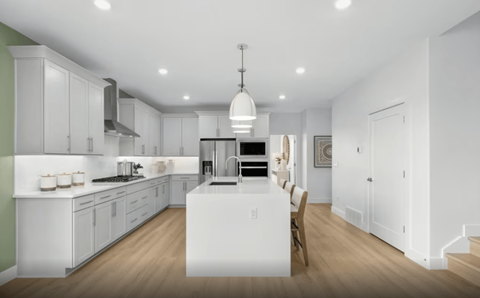 A modern kitchen with white cabinets and a large island.