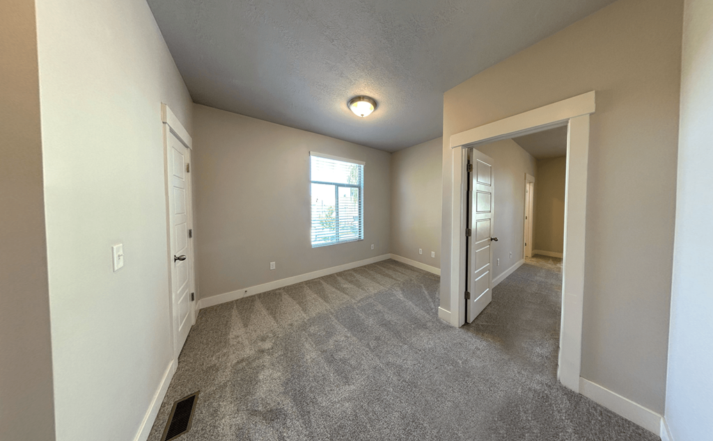 an empty living room with a closet and a window
