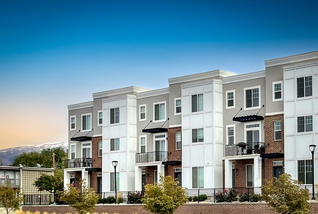 a row of apartment buildings with a mountain in the background