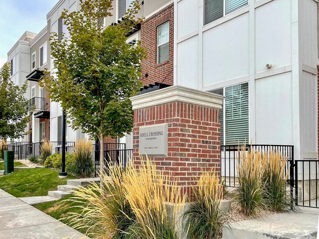 an apartment building with a sign in front of it
