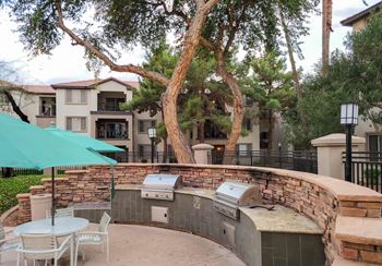 A patio with a table and chairs and a grill. at Sky at P83, Peoria, 85381