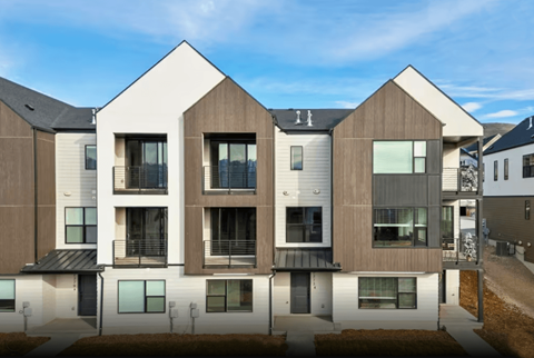 A modern residential building with a mix of white and brown exterior.