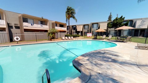 a large swimming pool with apartments in the background
