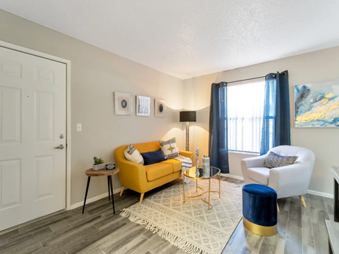 a living room with a yellow couch and a table