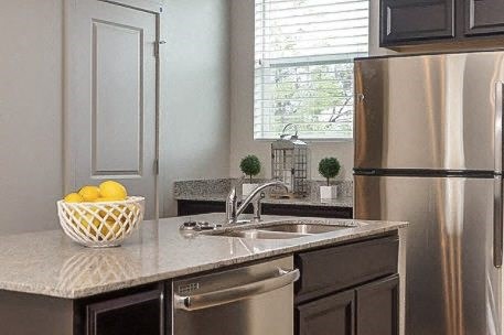a kitchen with a sink and a stainless steel refrigerator