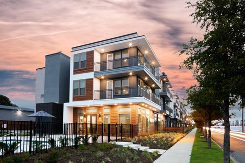 Modern apartment building exterior at dusk at Avion at West Lemmon Apartments, Dallas