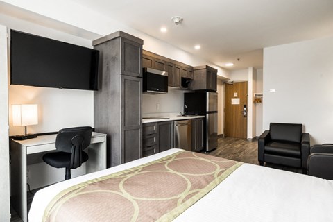 a hotel room with a bed and a kitchen