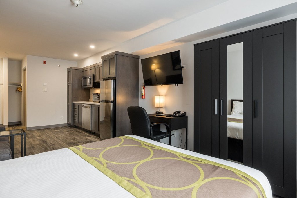 a hotel room with a bed and a kitchen