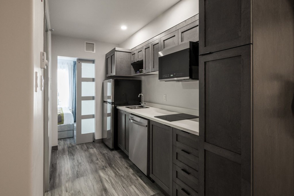 a kitchen with dark wood cabinets and a white counter top