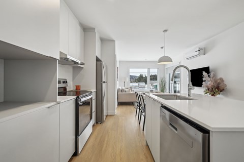 A modern kitchen with white cabinets and stainless steel appliances.