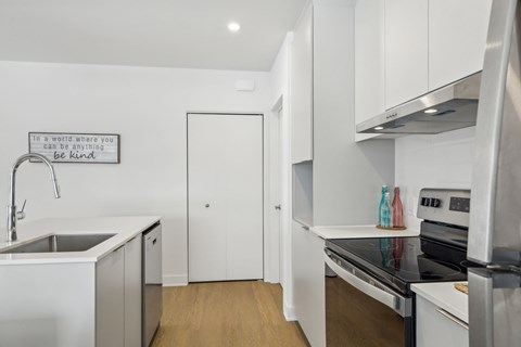 A kitchen with a quote on the wall that says "In a world where you can be anything, be kind".
